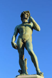 Low angle view of statue against blue sky