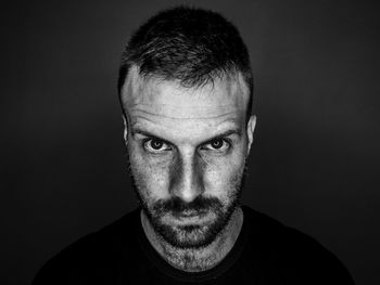 Close-up portrait of young man against black background