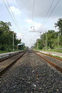 Railroad tracks amidst trees against sky