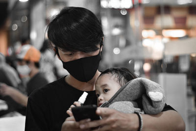 Man with daughter using mobile phone
