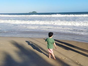 Rear view of boy looking at sea shore