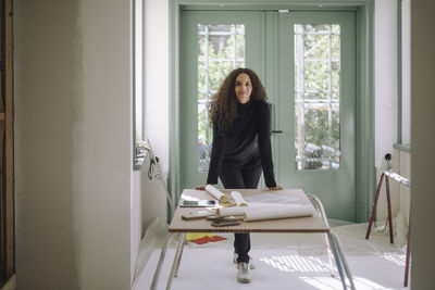 Portrait of young woman looking through window