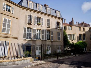 Residential building by street against sky