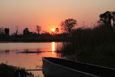 Scenic view of lake against orange sky