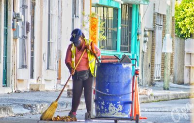 Man working on street against buildings in city