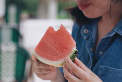 Midsection of woman holding fruit