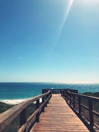 Pier over sea against blue sky