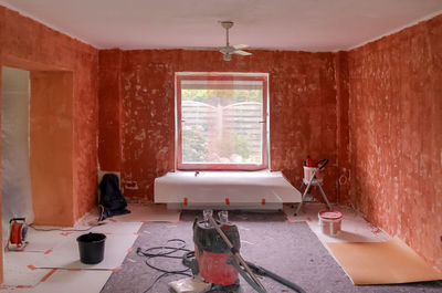 Renovation of a flat with red primer paint on the walls