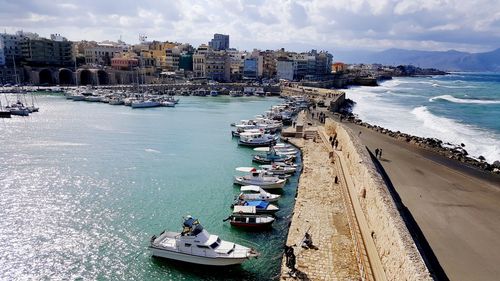 High angle view of sailboats moored at harbor in city