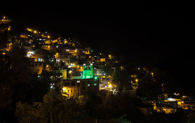 Illuminated cityscape against sky at night