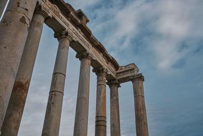 Low angle view of old ruin building against cloudy sky