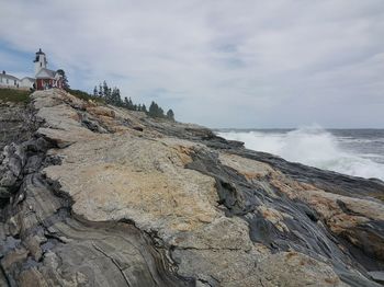 Rock formations on sea shore against sky