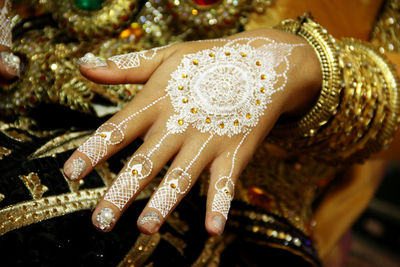 Midsection of bride showing white tattoos on hand