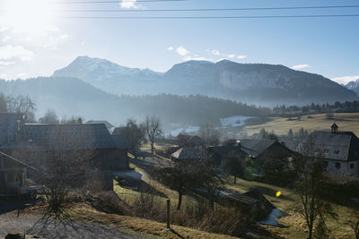 Aerial view of townscape by mountains against sky