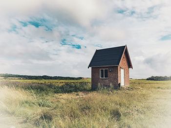 Abandoned house on field against sky