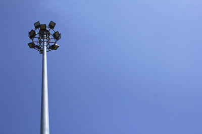 Low angle view of floodlight against blue sky