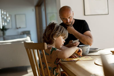 Father and son sitting at table