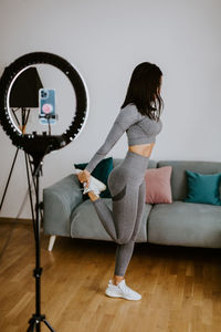 Woman standing on hardwood floor against wall at home