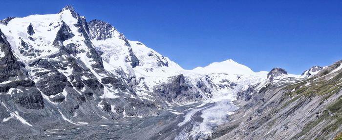 Scenic view of snowcapped mountains against clear blue sky