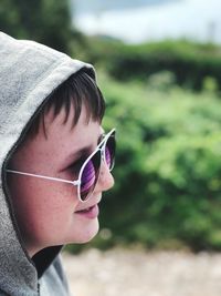 Close-up of boy wearing sunglasses against plants