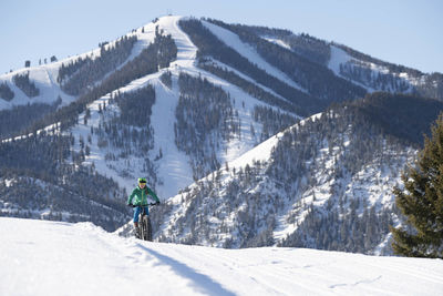 A woman riding her fat bike on a beautiful winter day in sun valley.