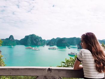 Woman looking at sea against sky