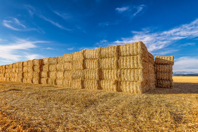 Scenic view of hay bales on harvested wheat field in provence against dramatic blue sky in summer