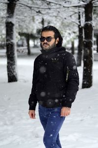 Man standing on snow covered tree during winter