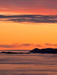 Scenic view of sea against dramatic sky during sunset