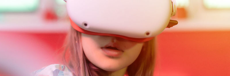 Vr game virtual reality. kid girl gamer playing on futuristic simulation video game in 3d glasses