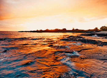 Scenic view of beach against sky during sunset