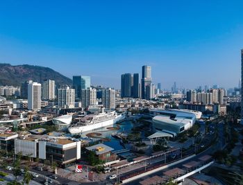 High angle view of buildings in city against clear blue sky