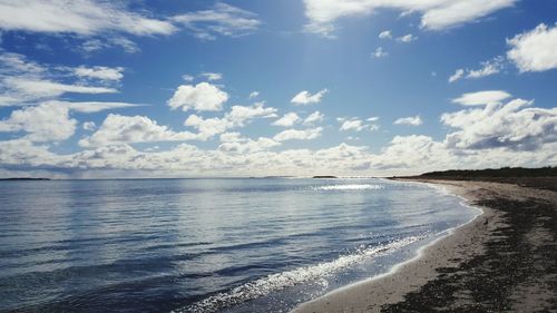 Scenic view of beach against blue sky