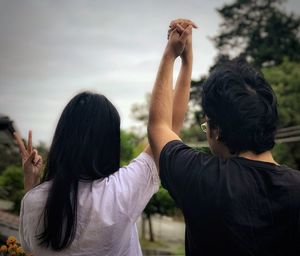 Rear view of friends standing against the sky