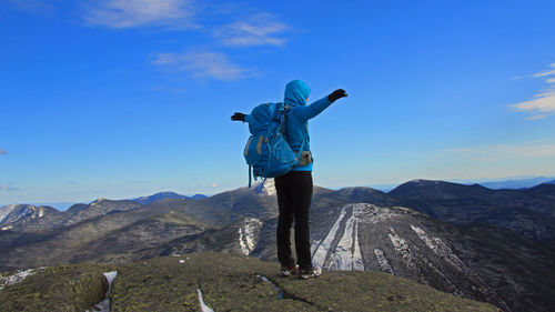 Man standing on mountain against blue sky