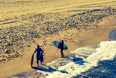 High angle view of people walking on sand