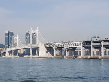 Bridge over sea against sky in city