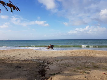 People at beach against sky