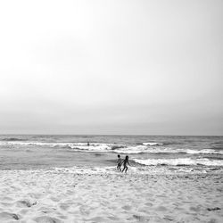 People enjoying on beach against sky