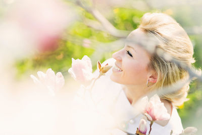 Close-up of woman with pink flower