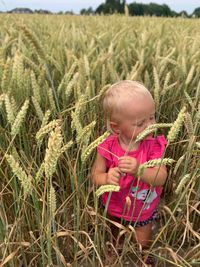Cute baby girl standing on field