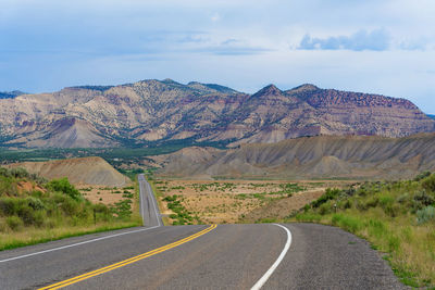 Road by mountain against sky