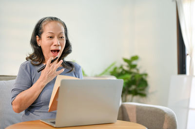 Young woman using laptop while sitting at home