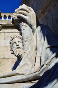 Low angle view of angel statue against wall