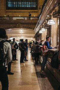 Group of people walking in illuminated corridor