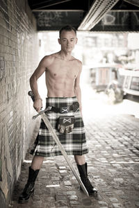 Portrait of young man standing against wall