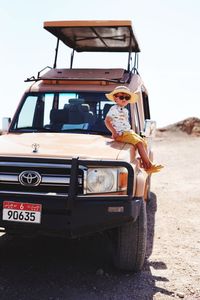 Portrait of man on car against sky