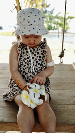 Toddler girl sitting with bunch of flowers