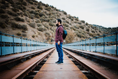 Rear view of man standing on railroad track