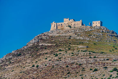 Low angle view of fort against clear blue sky